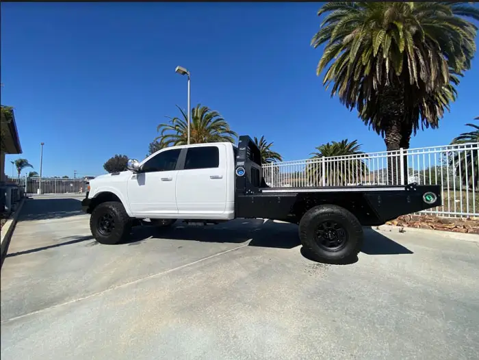 Side profile of a white Ram chassis cab with a 60 inch cab to axle measurement, fitted with an Aluma Tray HD-60