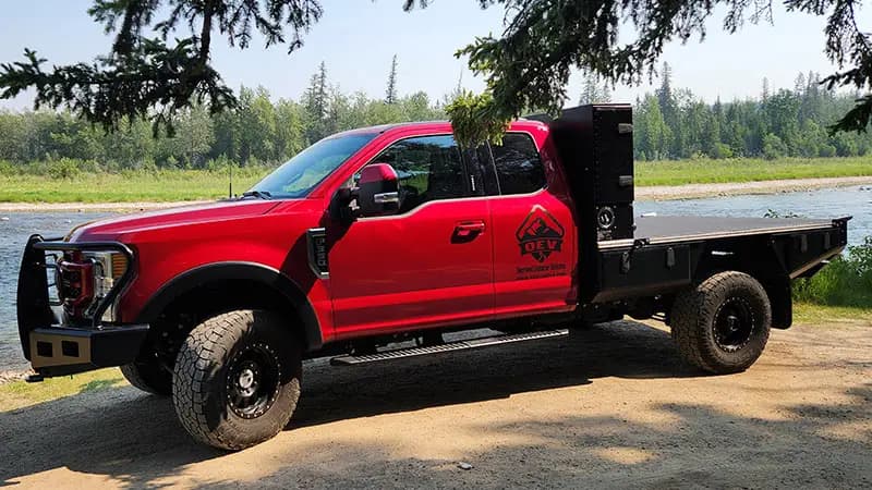 Aluma Tray 8 foot aluminum flatbed on a red pickup parked beside a river